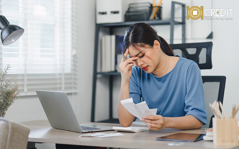 Stressed woman reviewing bills to plan her loan repayment