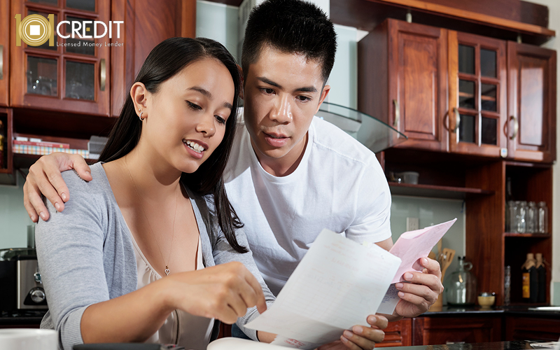 Couple reviewing bills to calculate their debt-to-income ratio.
