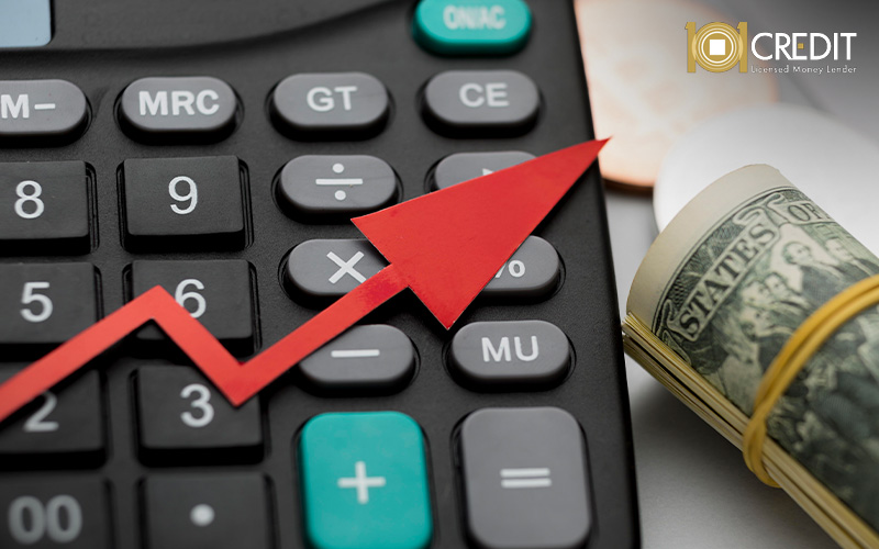 Close-up of a calculator and rolled US dollar banknotes.