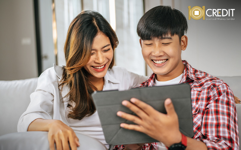 Smiling couple exploring digital loan options on a tablet.