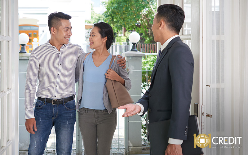 A happy couple being greeted at the door by a professional consultant