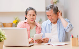Old couple looking stressed over bills.