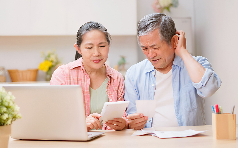 Old couple looking stressed over bills.